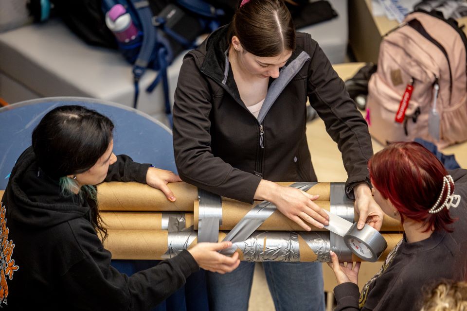 School of Science and Engineering students construct a bridge out of cardboard and duct tape during the SSE Innovation Challenge with industry partner TWM on Wednesday, Nov. 13, 2024. Photo by Sarah Conroy. 