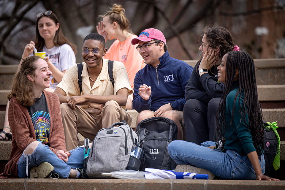 SLU 101 leader and students hanging out at the clock tower plaza