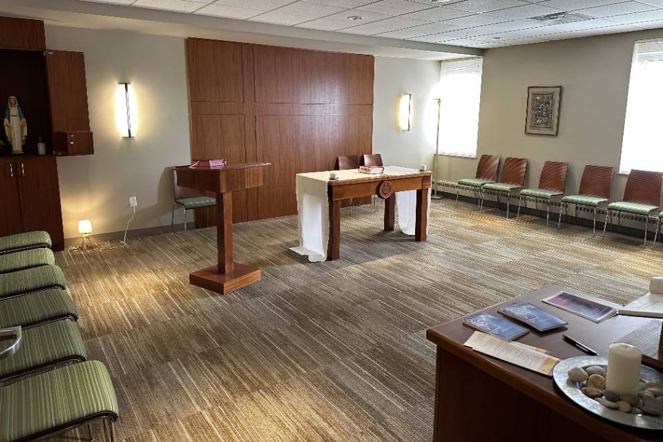 Interior of a room with chairs lining each side and an altar area in the middle.