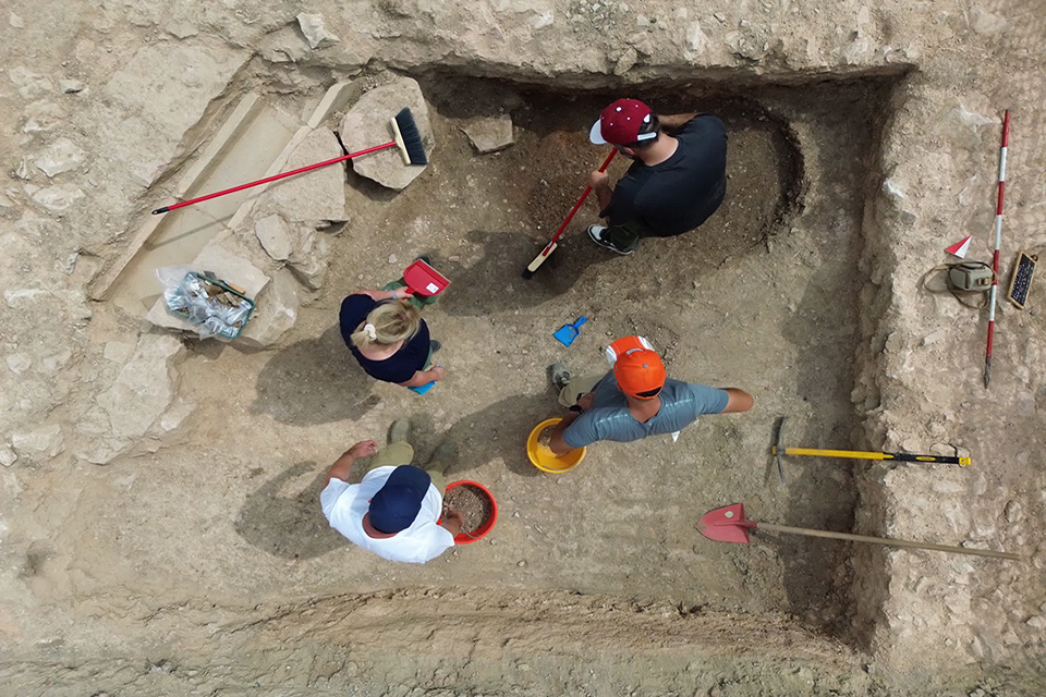 Excavators are seen from above working at the site, with brooms, shovels and buckets.