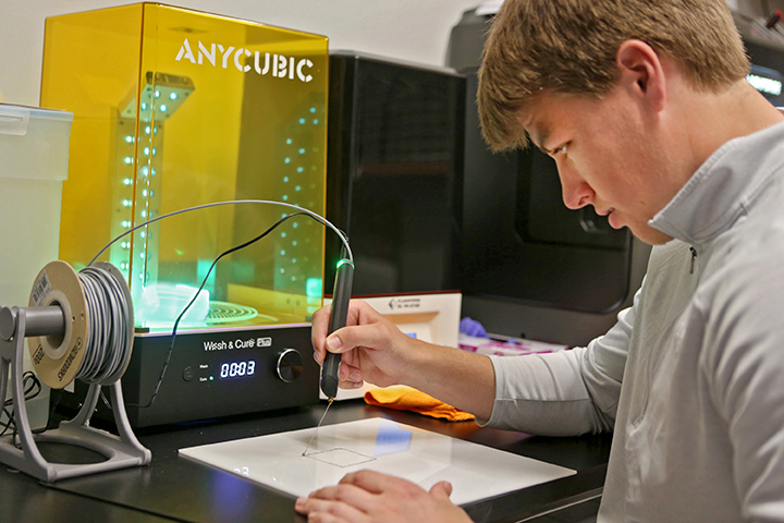 Student using 3D printer in engineering lab