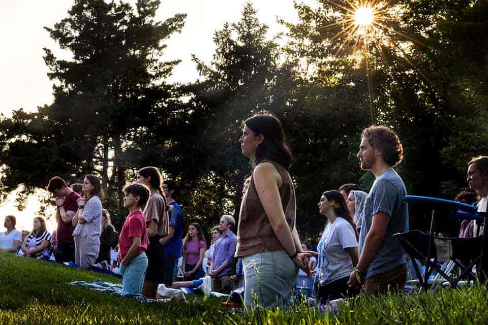 Congregants stand during an outdoor Mass